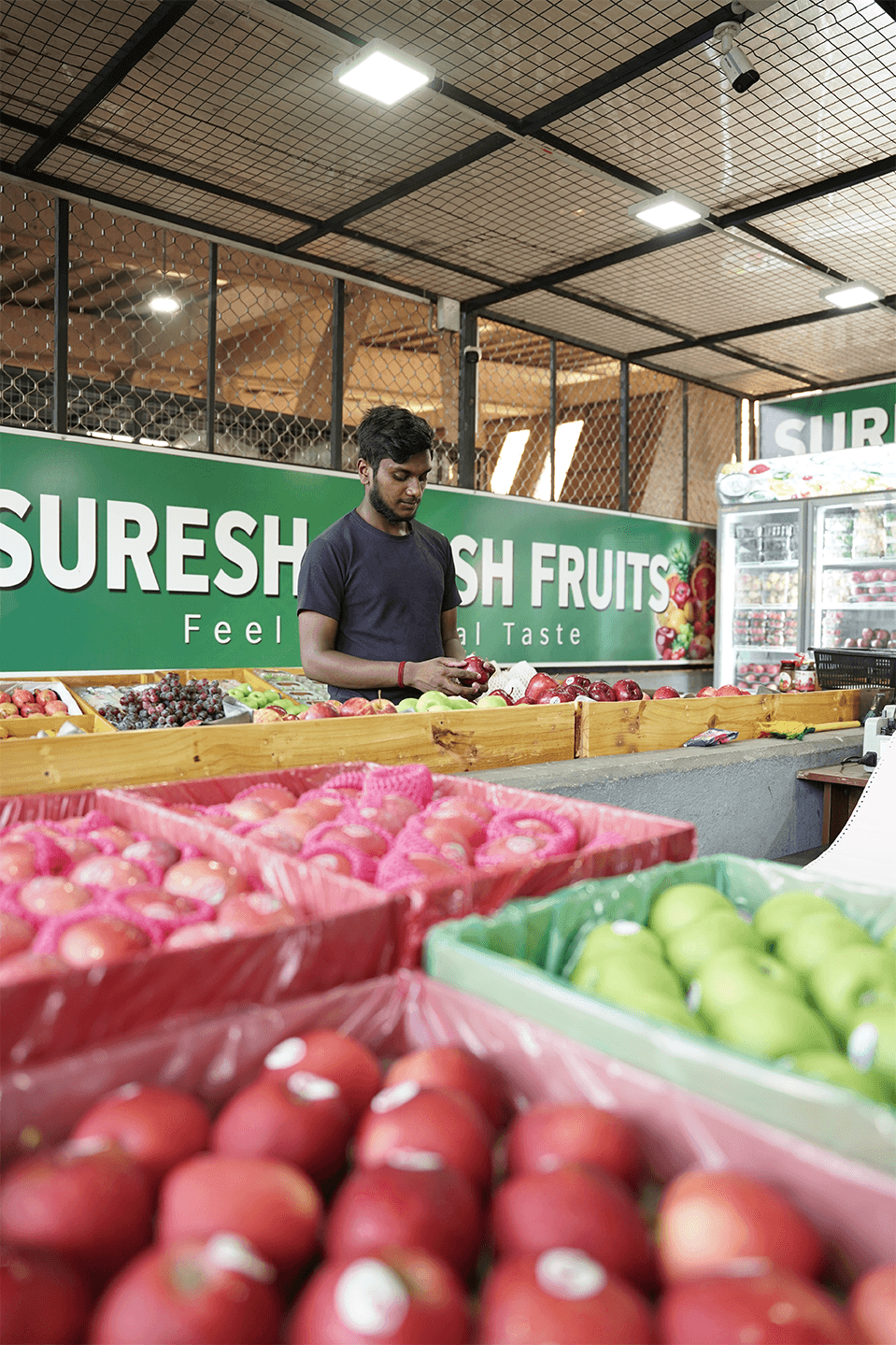 Team member selecting apples at the Suresh Fresh Fruits stall