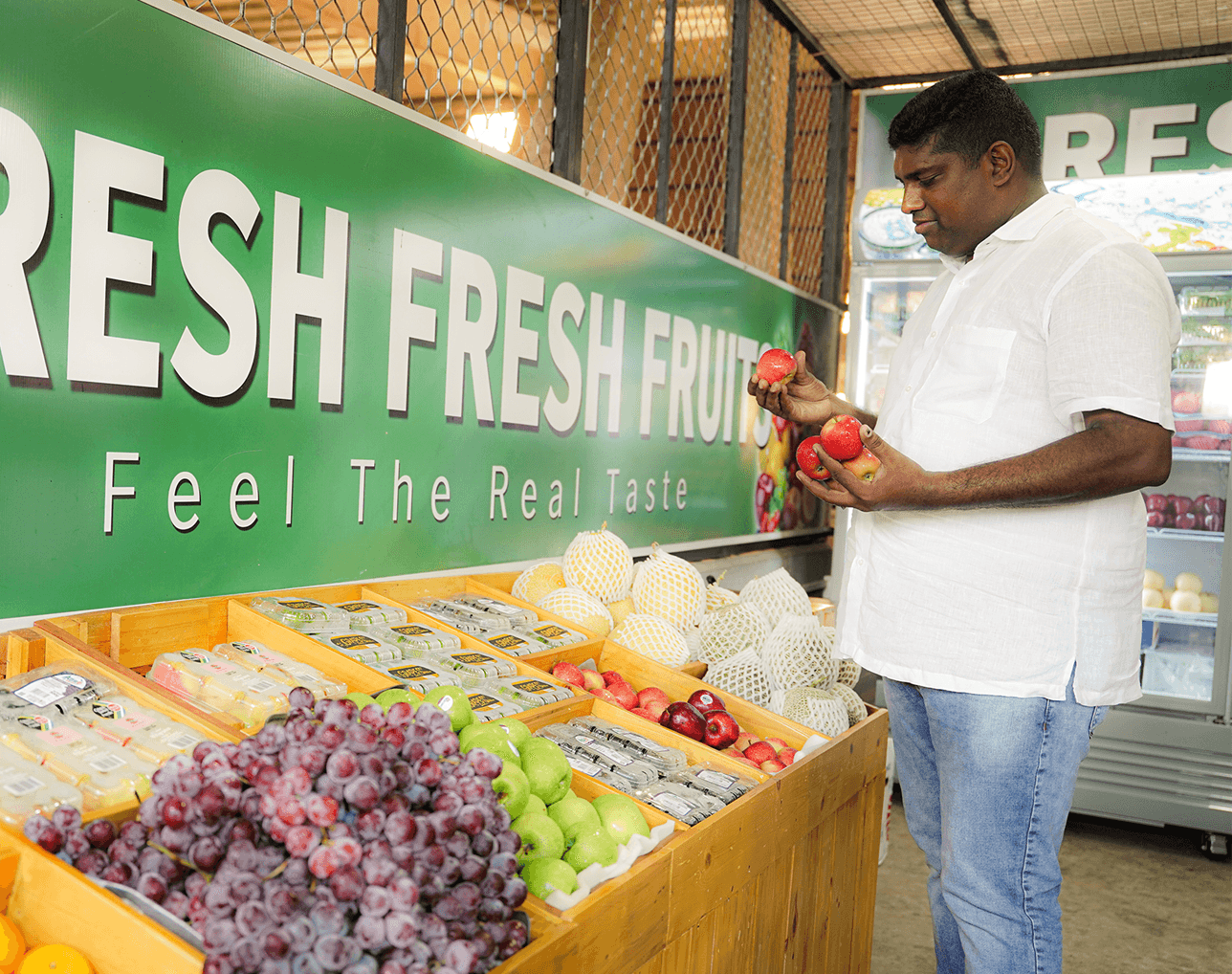 Suresh Fresh Fruit founder checking red apples at the market stall